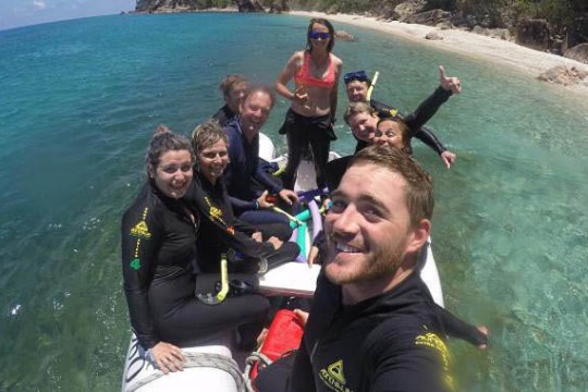 a group of people standing next to a body of water
