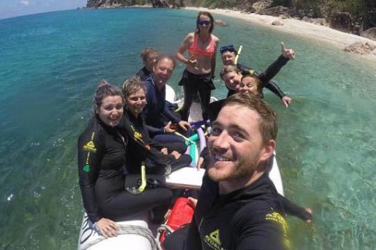 a group of people standing next to a body of water