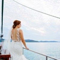 a person standing in front of a boat next to a body of water