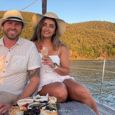 a man and woman sitting next to a body of water