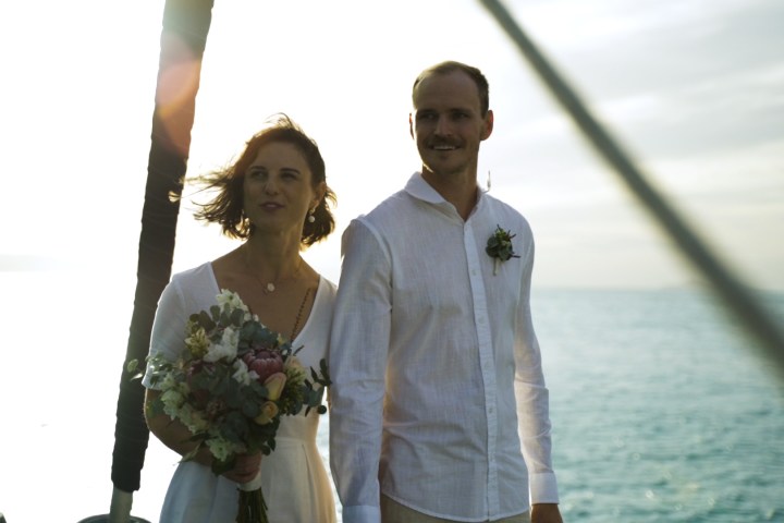 a man and a woman standing in front of water