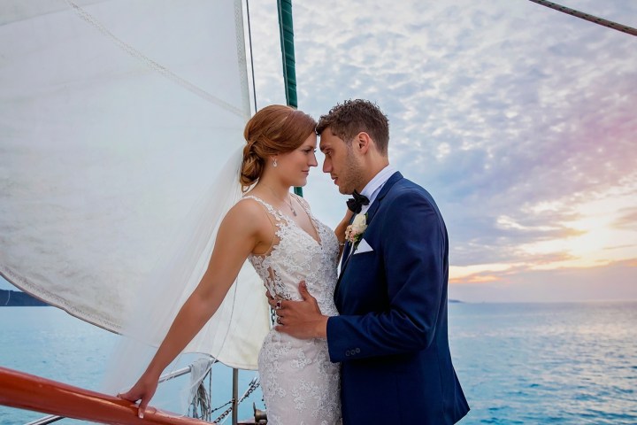 a man and a woman standing next to a body of water